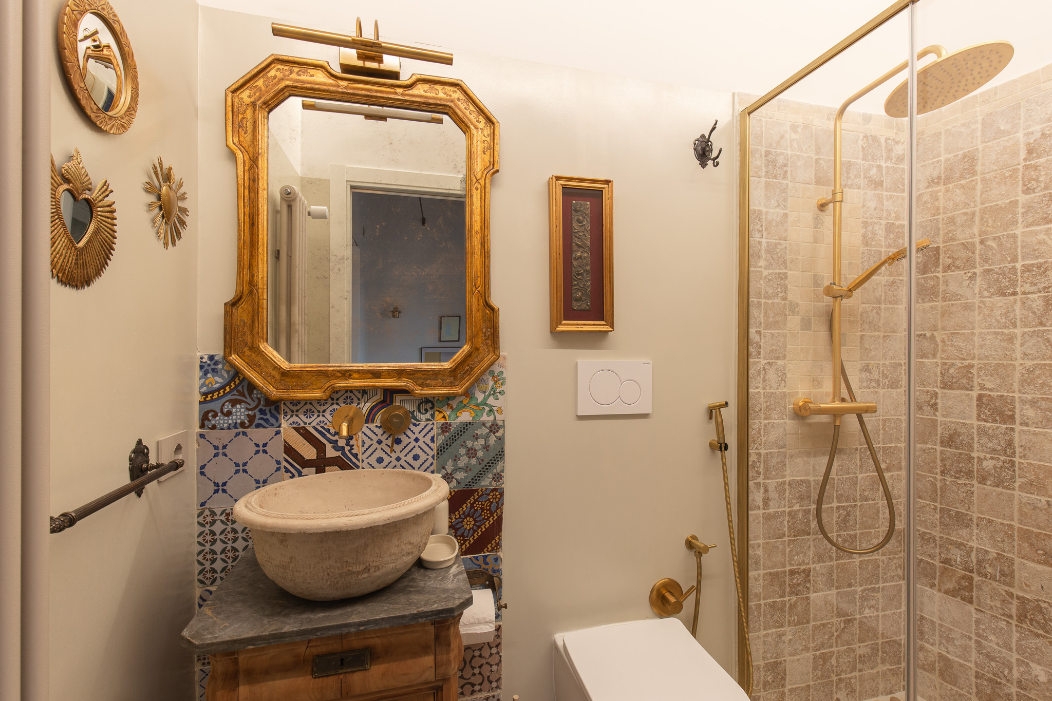 Bagno con doccia e specchio dorato